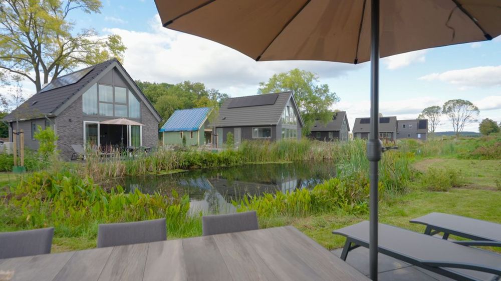 Impressie van een park met zandstrand aan het water